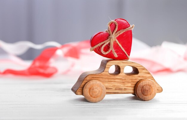 Coche de madera decorativo con figura de corazón en la mesa