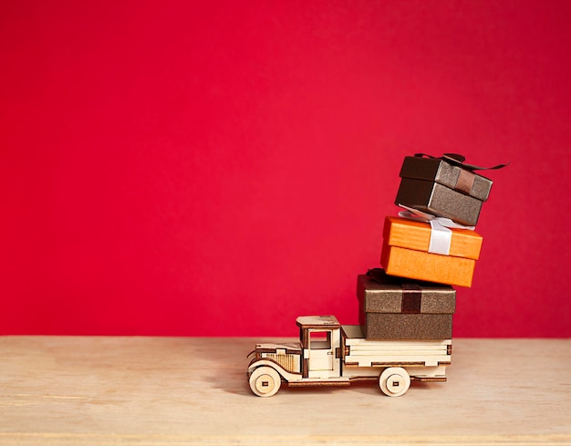 coche de madera lleva cajas de regalo sobre un fondo rojo