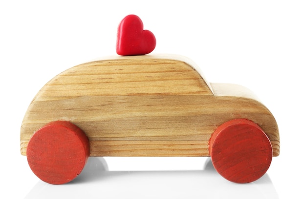 Coche de madera con una pequeña figura de corazón rojo aislado en blanco