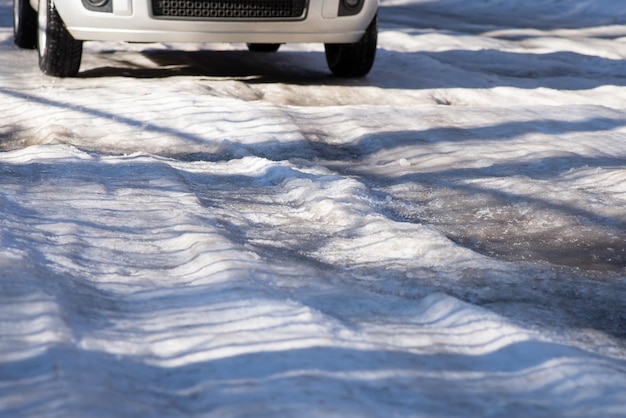 Coche moviéndose a lo largo de carretera congelada en invierno Camino cubierto de hielo nunca limpiado peligroso para conducir