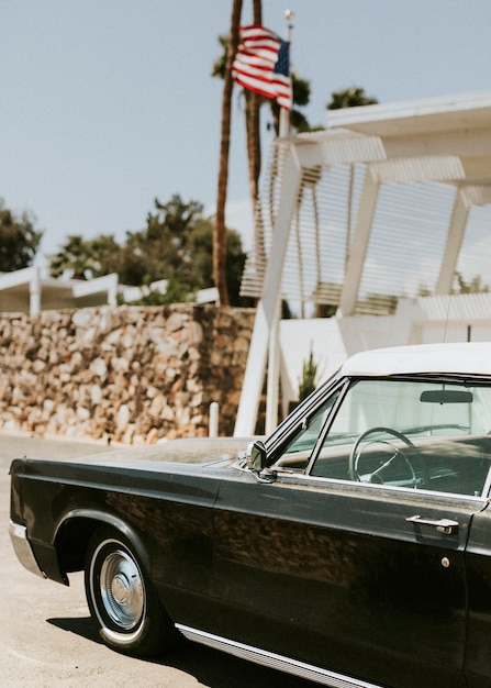 Foto coche negro clásico estacionado fuera de una casa