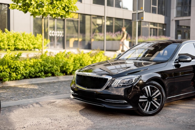 Coche negro de lujo en una calle cerca de un edificio de oficinas