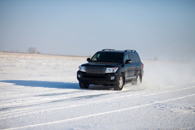 Coche negro viajando en la nieve.