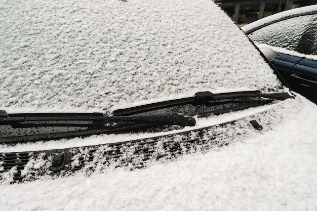 Coche con un parabrisas cubierto de nieve por la mañana