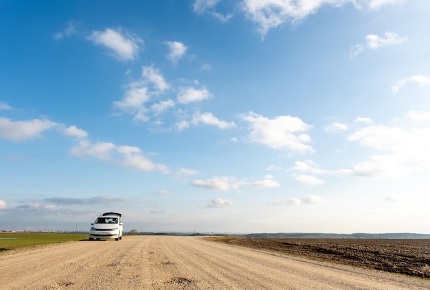 Foto coche de pie en la carretera en un campo con el maletero abierto