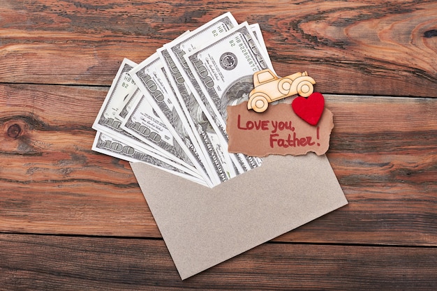 Coche de pirograbado cerca del dinero. Te amo tarjeta de felicitación del padre. Haz un regalo especial para papá.