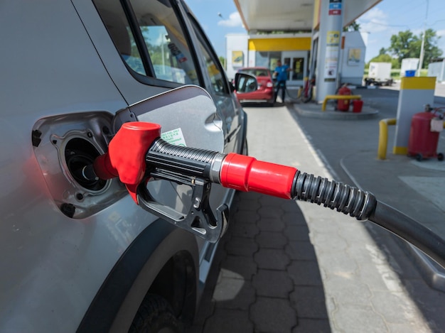 Coche plateado repostando en la gasolinera el concepto de energía de combustible