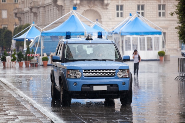 Coche de policía italiano bajo la lluvia