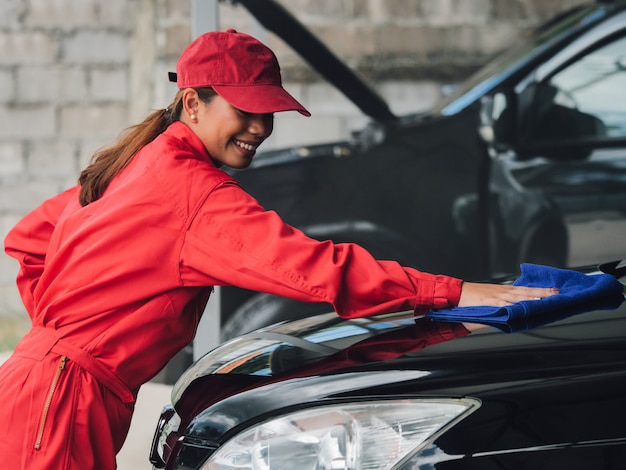 Coche que se lava de la mujer asiática.