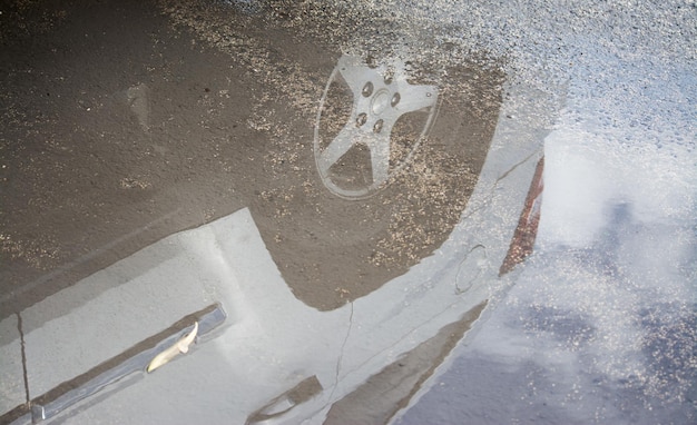 Coche reflejado en un charco urbano