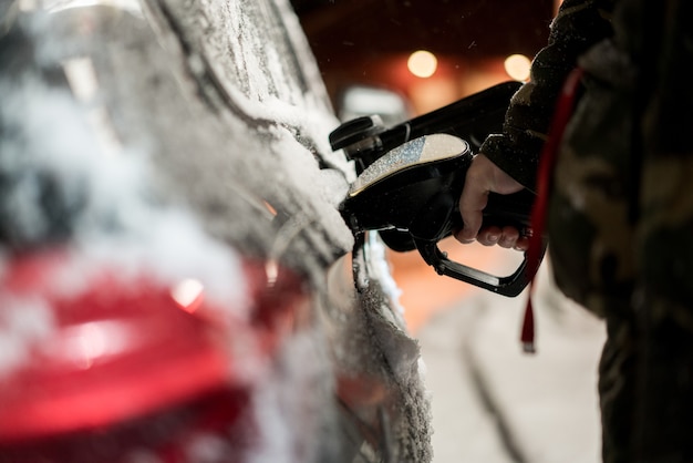 Coche de repostaje de noche de invierno con combustible.