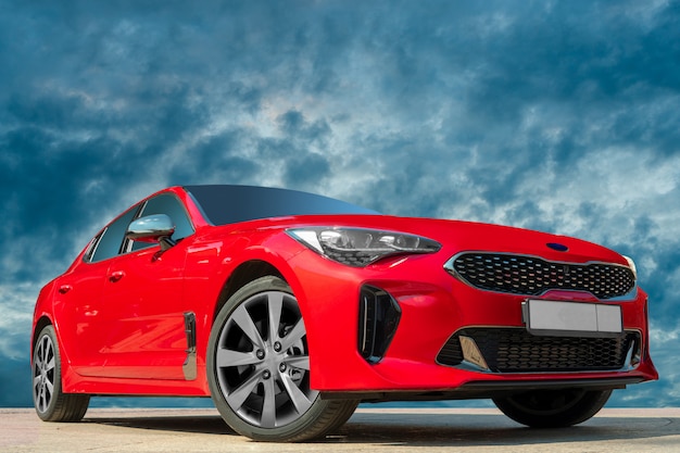 Foto coche rojo contra el fondo del cielo de la tarde.