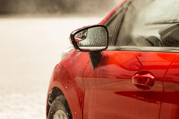 Un coche rojo con un parabrisas cubierto de nieve