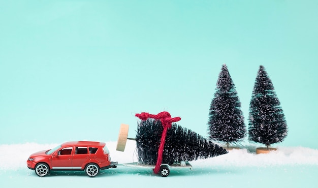 Coche rojo y remolque con un árbol de Navidad.