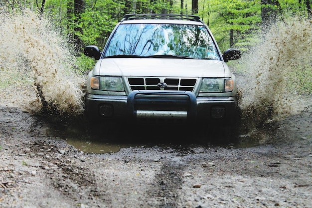El coche salpicando agua mientras se mueve en el bosque