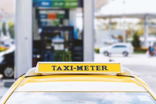 Foto coche de taxi cercano con enfoque suave y luz en el fondo.