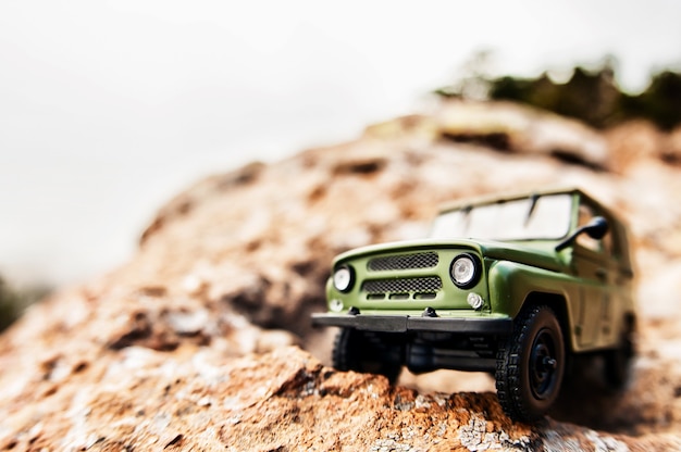 Coche todoterreno 4x4 en miniatura al borde de un acantilado