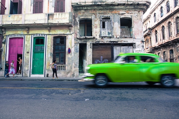 Foto coche verde en la calle contra los edificios