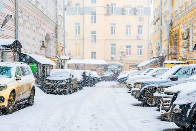 Coches aparcados cubiertos de nieve en el paisaje urbano del barrio de la ciudad f