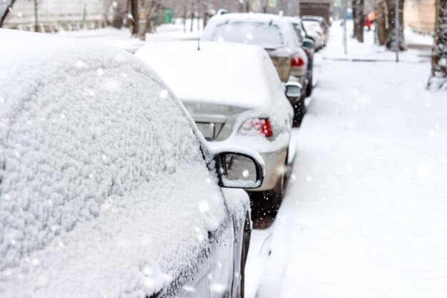 Los coches aparcados en la nieve. Escena urbana de invierno