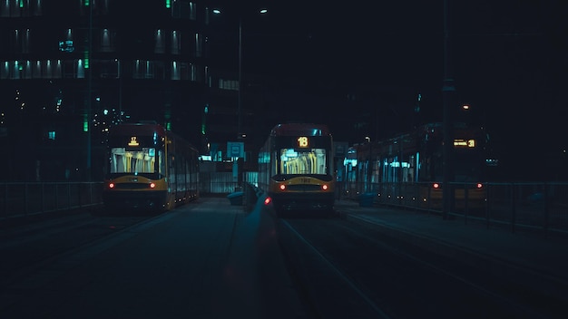 Los coches de cables iluminados en la ciudad por la noche