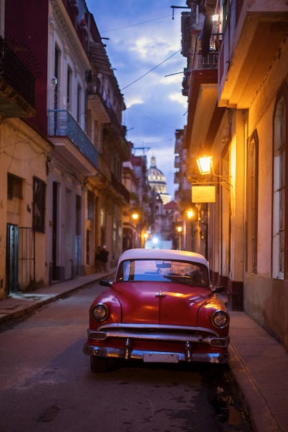 Foto coches en la calle por edificios iluminados en la ciudad por la noche