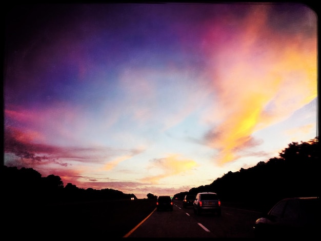 Foto coches en la carretera al atardecer