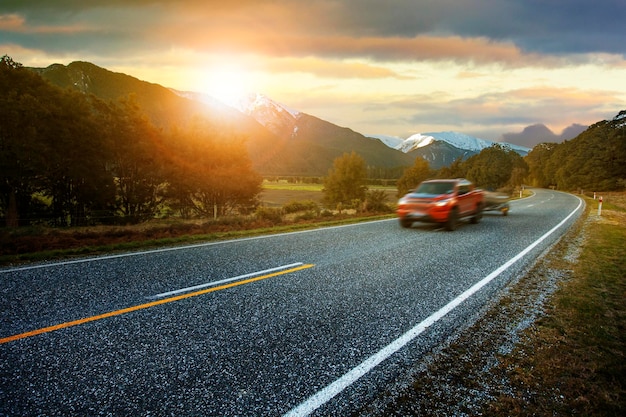 Coches en la carretera contra el cielo durante la puesta de sol