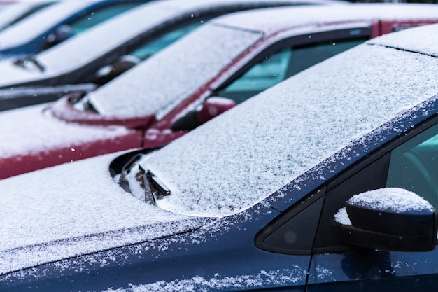 Coches cubiertos de nieve en el aparcamiento.