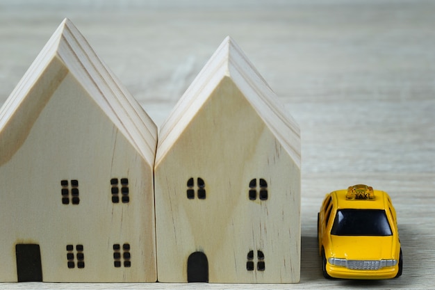 Coches de juguete y casas de madera en concepto de compra de vivienda y seguro o concepto de viaje.