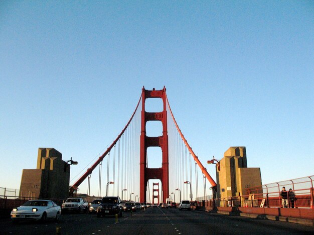 Foto coches en el puente de la puerta dorada contra el cielo despejado en la ciudad durante un día soleado