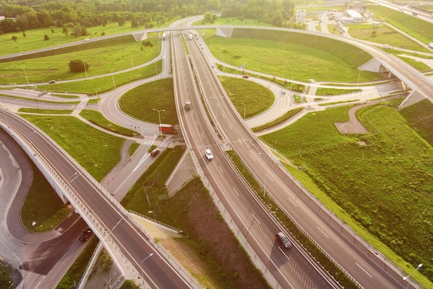 Coches que se mueven en el cruce de carreteras de transporte en la vista aérea de la ciudad