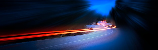 Coches senderos de luz por la noche en una curva carretera de montaña de asfalto por la noche panorama de imagen de larga exposición