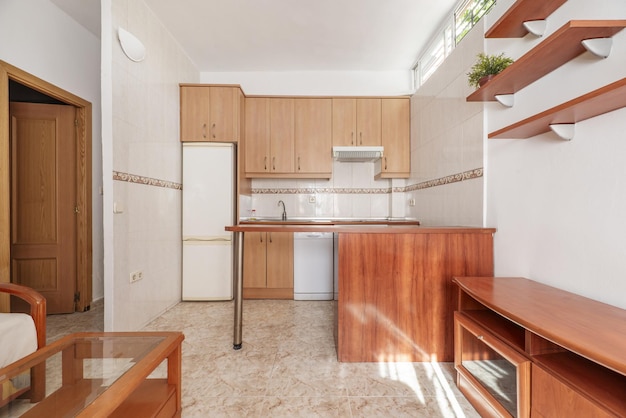 Cocina abierta al salón amueblada en un loft con electrodomésticos blancos empotrados