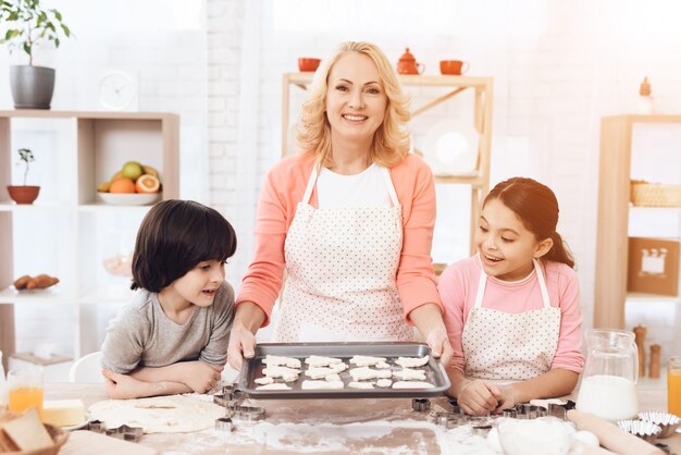 Cocina de la abuela que hornea las galletas con los nietos