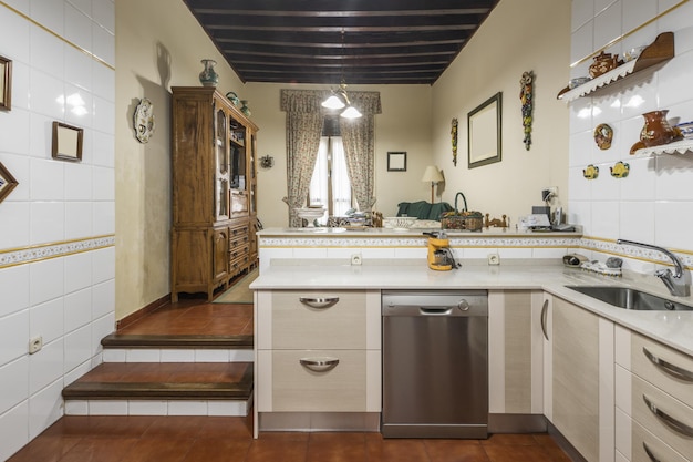 Cocina amueblada con muebles bajos en blanco y alicatado marrón bicolor en suelos y paredes