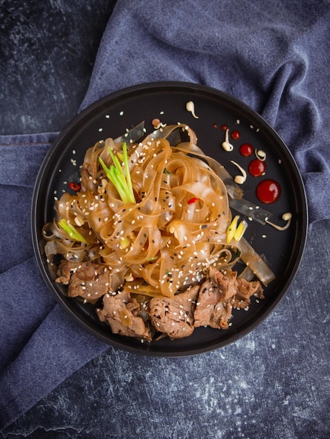 Cocina asiática, fideos de carne asiáticos picantes en la oscuridad