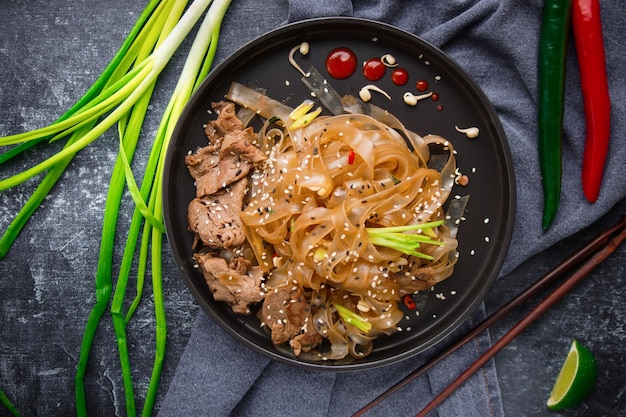 Cocina asiática, fideos de carne asiáticos picantes en la oscuridad