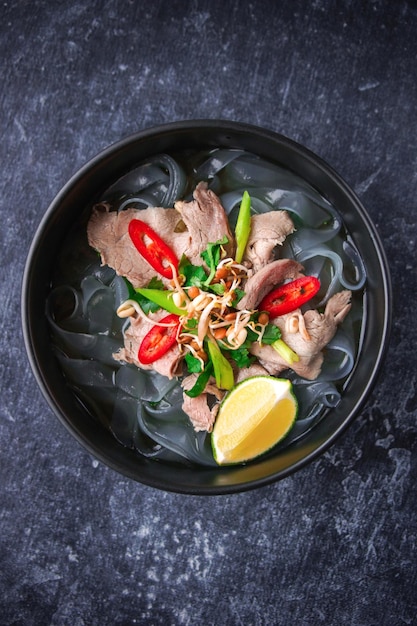Cocina asiática, sopa pho bo vietnamita en un plato negro sobre un fondo oscuro