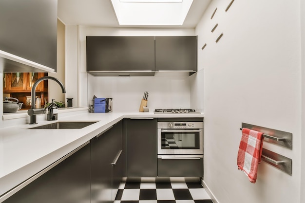 Una cocina con azulejos blancos y negros y un fregadero.
