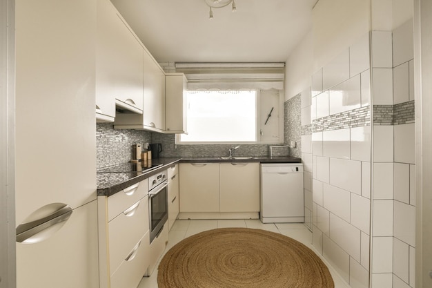 Una cocina blanca con una alfombra en el centro.