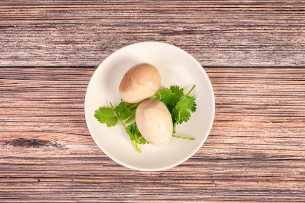 Cocina china, huevos marinados en el plato están sobre la mesa de madera