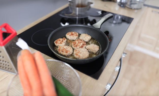 En la cocina, las chuletas se fríen en una sartén.