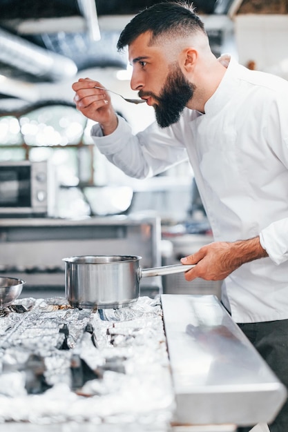 Cocina deliciosa sopa Chef en uniforme blanco cocinando comida en la cocina Día ajetreado en el trabajo