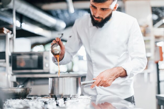 Cocina deliciosa sopa Chef en uniforme blanco cocinando comida en la cocina Día ajetreado en el trabajo