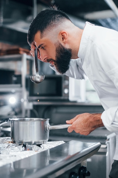 Cocina deliciosa sopa Chef en uniforme blanco cocinando comida en la cocina Día ajetreado en el trabajo