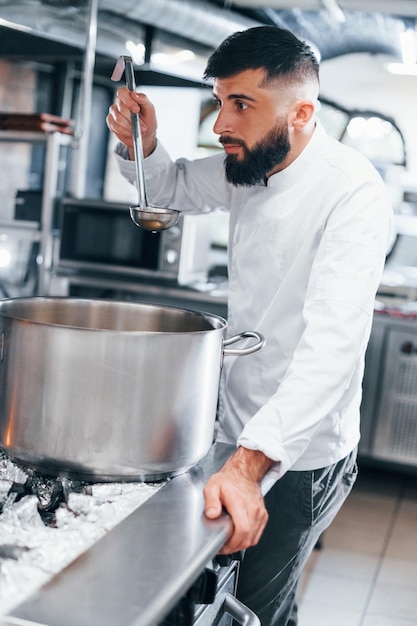 Cocina deliciosa sopa Chef en uniforme blanco cocinando comida en la cocina Día ajetreado en el trabajo