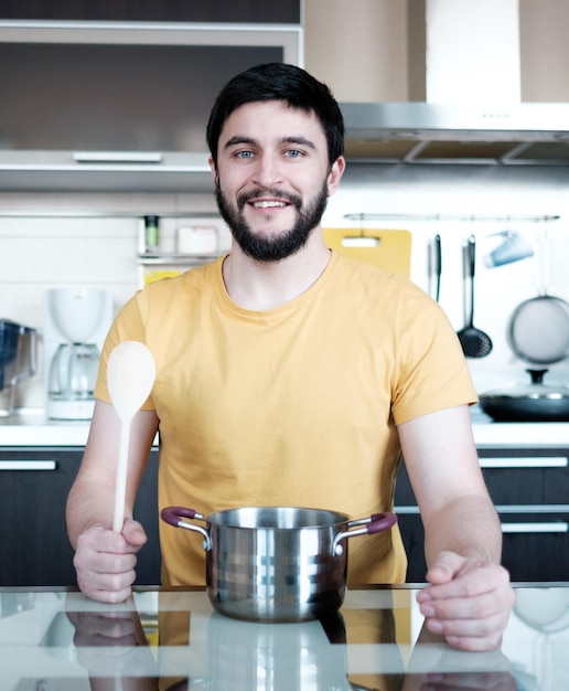 Cocina divertida Hombre caucásico atractivo en la cocina