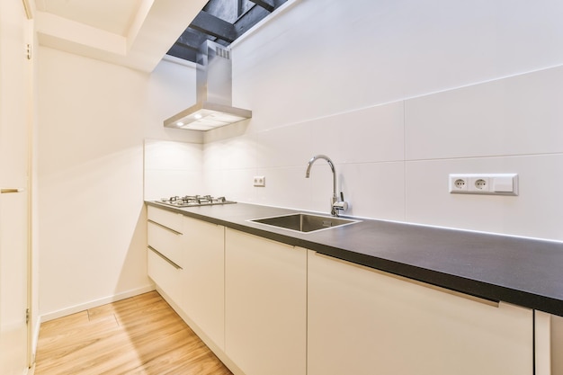 Cocina de estilo minimalista en blanco en una pequeña y acogedora casa