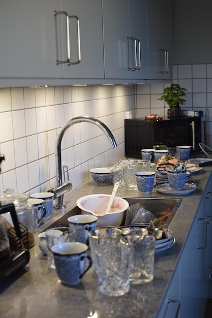 Una cocina con un fregadero, un grifo y un fregadero con platos.